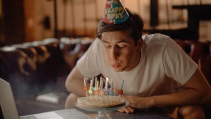 Man blowing the candles on his birthday cake