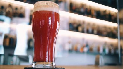 A selective focus of a glass of red beer on a bar table