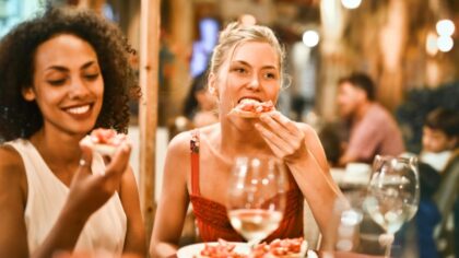 Two women eating pastries