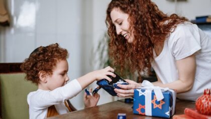 Mother is unwrapping presents with her child