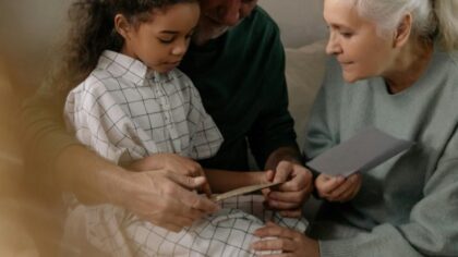 Grandparents and dranddaughter are looking at photos together
