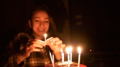 Girl is holding a birthday candle from her cake