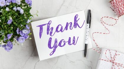 A "Thank you" card with pen and flowers
