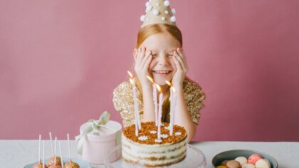 Little girl is happy about her birthday cake