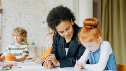 A teacher assisting her student