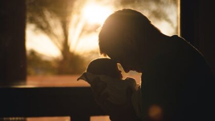 Father hugging his son in front of the sunset